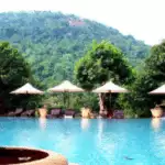 Ein Swimmingpool mit Liegestühlen und Sonnenschirmen.
